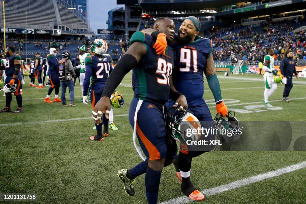 Anthony Johnson of the Seattle Dragons, right, hugging teammate, Kenneth Farrow, as they left the field after defeating the Tampa Bay Vipers at...