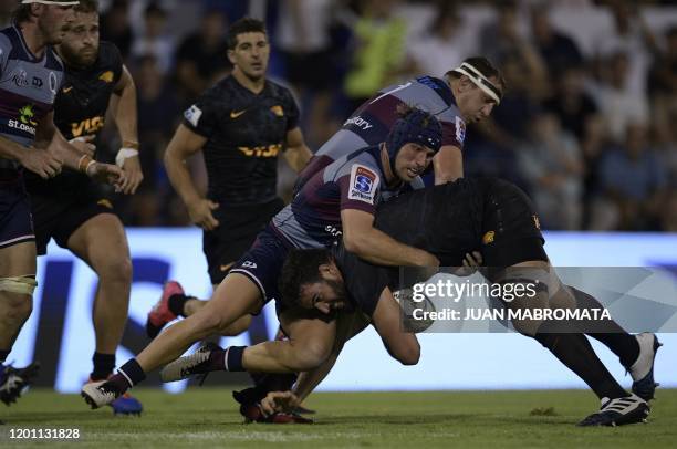 Argentina's Jaguares lock Lucas Paulos is tackled by Australia's Reds centre Hamish Stewart and prop JP Smith during the Super Rugby match at Jose...