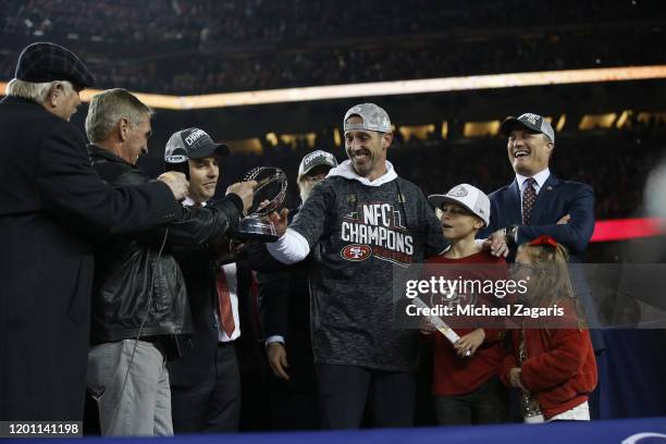 Mike Shanahan hands the NFC championship trophy to Head Coach Kyle Shanahan of the San Francisco 49ers during the NFC Championship trophy ceremony...