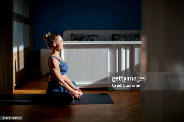 mujer meditando en ángulo atado pose - yoga caliente fotografías e imágenes de stock