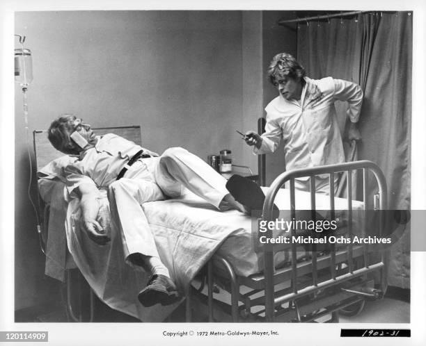 James Coburn tries to get away from Michael Blodgett in a scene from the film 'The Carey Treatment', 1972.