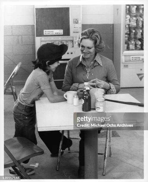 Michael Hershewe and Alexis Smith at break room table in a scene from the film 'Casey's Shadow', 1978.