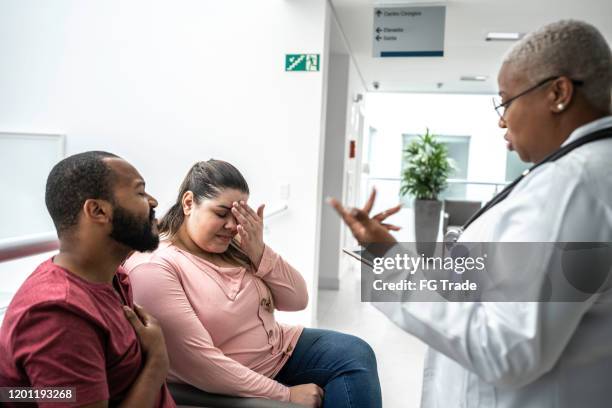 female doctor talking about medical test to her patients at hospital - medicaid stock pictures, royalty-free photos & images