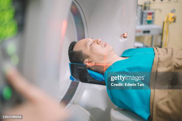 an asian malay male patient lying down for hospital cat scan - patient lying down stock pictures, royalty-free photos & images