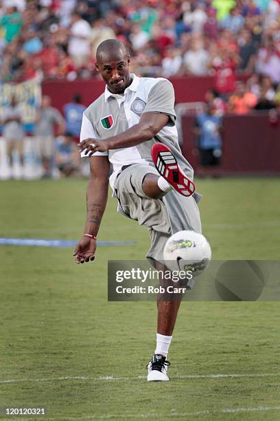 Basketball player Kobe Bryant kicks a soccer ball during half time of the Manchester United and Barcelona friendly match at FedExField on July 30,...