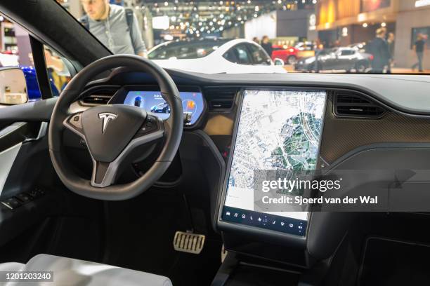 Interior on a Tesla Model X full electric luxury crossover SUV car with a large touch screen and carbon look dashboard on display at Brussels Expo on...