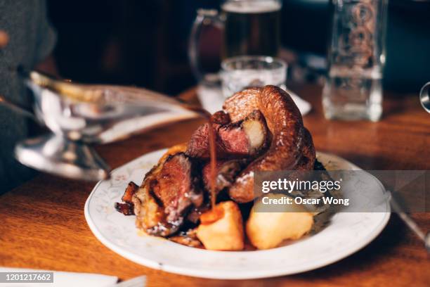 pouring gravy over roasted meat - rôti photos et images de collection