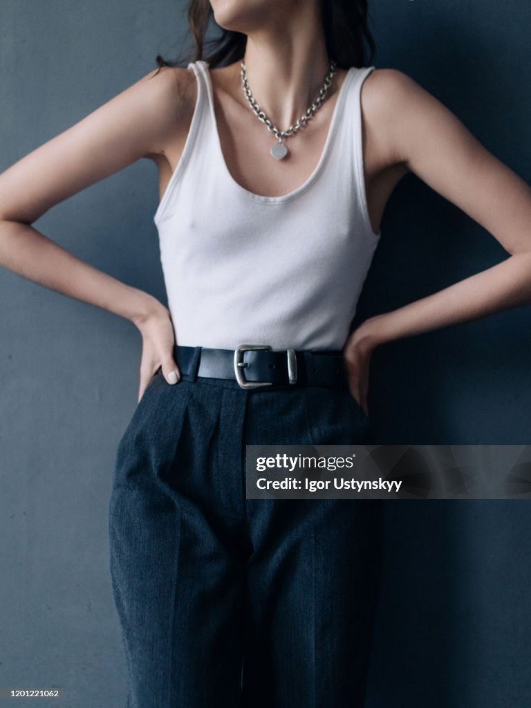 Midsection of woman standing against gray background