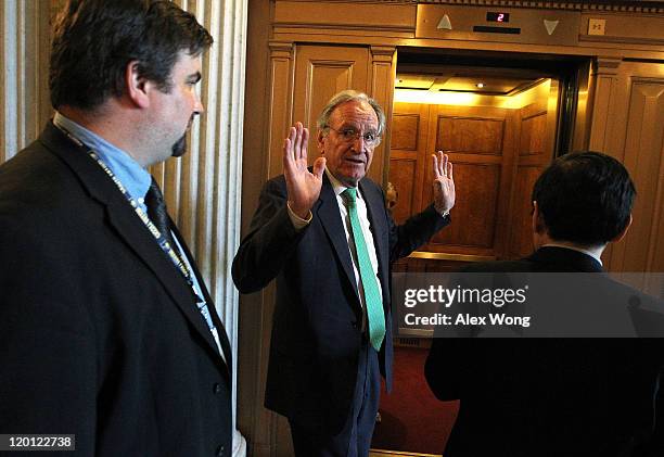 Sen. Tom Harkin gestures as he is followed by members of the press July 30, 2011 at the Capitol in Washington, DC. Members of the Congress continued...
