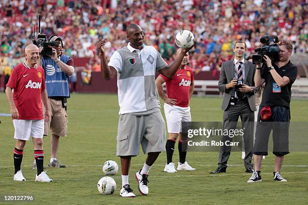 Basketball player Kobe Bryant reacts to the crowd during a half time event at the Manchester United and Barcelona friendly match at FedExField on...