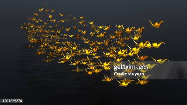 golden origami cranes flying on ship type - animaux origami photos et images de collection