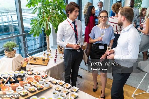 business people socialising and drinking champagne at a banquet - food and drink production stock pictures, royalty-free photos & images