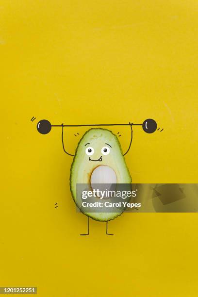 funny avocado charactert  with dumbbells at gym - funny vegetable stockfoto's en -beelden