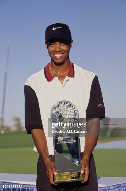 Tiger Woods of the United States celebrates with the trophy after winning his first professional golf tournament at the PGA Las Vegas Invitational on...