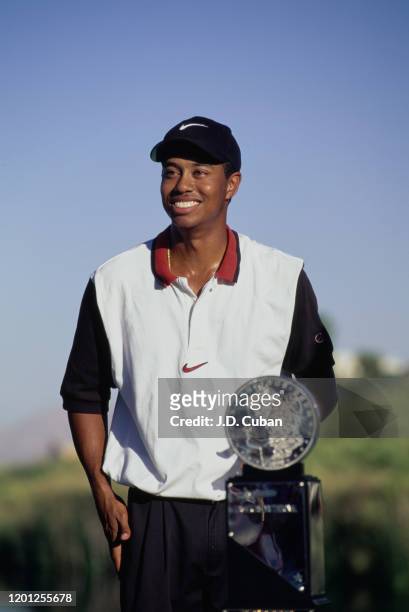Tiger Woods of the United States celebrates with the trophy after winning his first professional golf tournament at the PGA Las Vegas Invitational on...