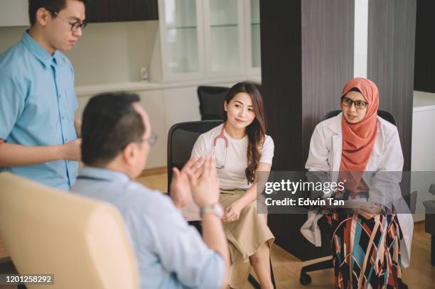 een groep multi-ethic artsen die in het ziekenhuis een discussie voeren in het ziekenhuis - huisarts stockfoto's en -beelden