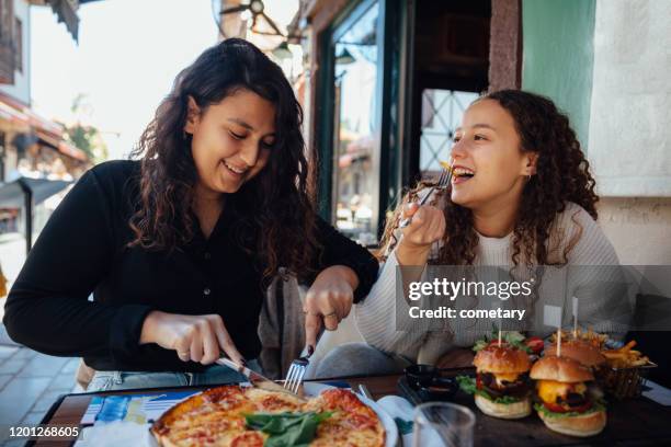 young woman eating fast food - mediterranean turkey burger stock pictures, royalty-free photos & images