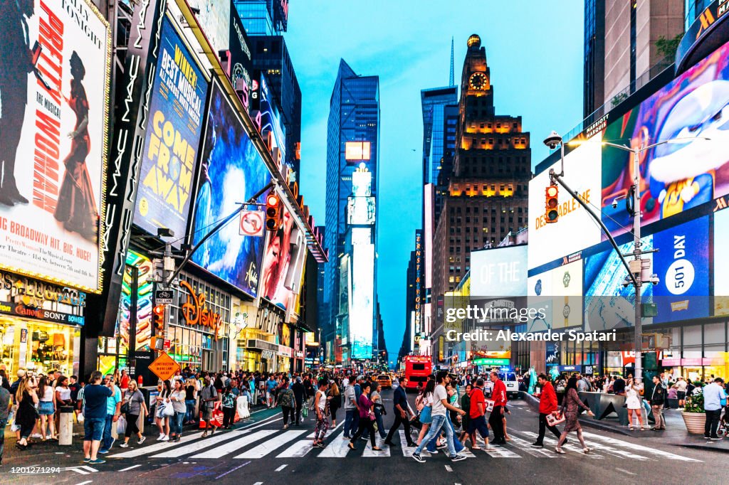 Crowds of people walking at Times Square at night, New York, USA