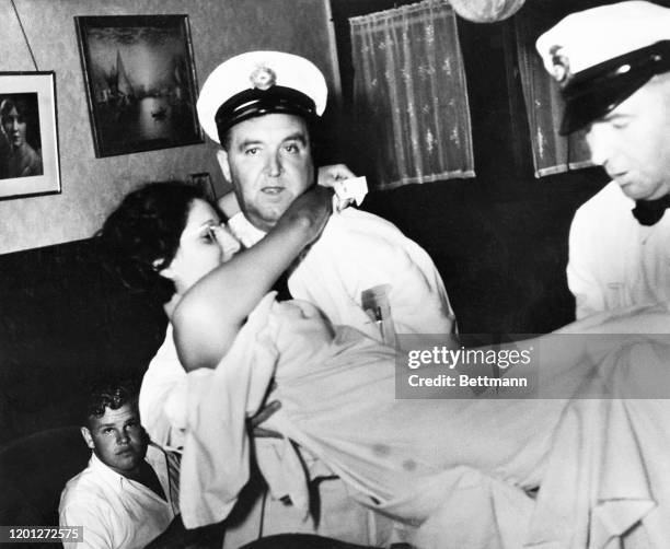 General Hospital Attendants removing Mary Kern from the Van Ness Avenue apartment of Harley and Rose Marie Heddens, San Francisco, August 1935. The...