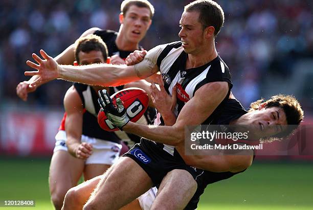 Nick Maxwell of the Magpies is tackled by Angus Monfries of the Bombers during the round 19 AFL match between the Collingwood Magpies and the...