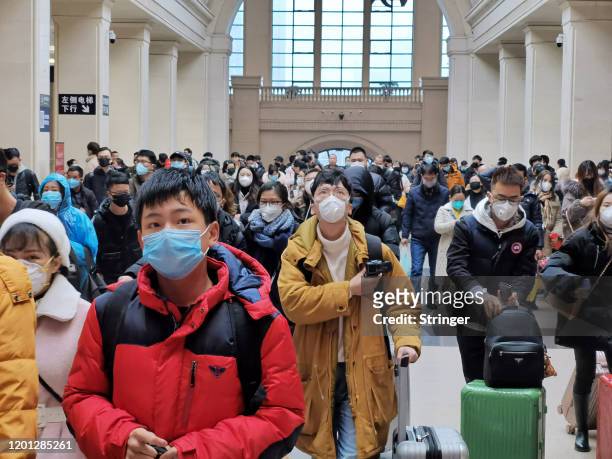 People wear face masks as they wait at Hankou Railway Station on January 22, 2020 in Wuhan, China. A new infectious coronavirus known as "2019-nCoV"...