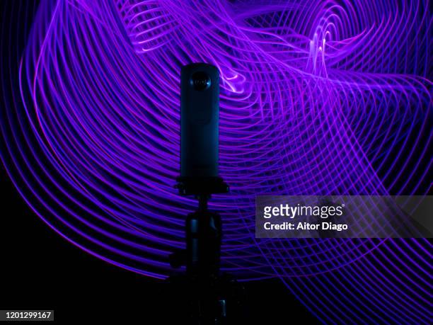 close up of a 360º camera on a tripod with a purple futuristic interconnected background - 360 fotografías e imágenes de stock