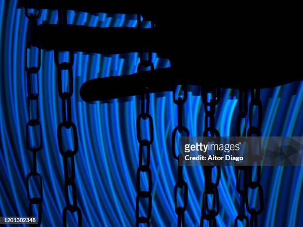 close up of man´s hand in movement touching a chain. blue futuristic tone. - human trafficking stock pictures, royalty-free photos & images