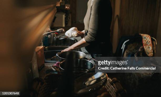 doing dishes - crowded home stock-fotos und bilder