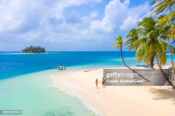 a young couple strolling on a tropical island. san blas islands, panama - couple beach imagens e fotografias de stock
