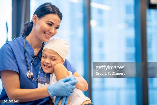 enfermera hugging joven cancer paciente foto de stock - pediatrician fotografías e imágenes de stock