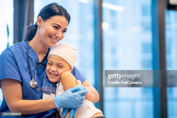 verpleegster die jonge patiënt van de kanker voorraadfoto koestert - nurse and patient stockfoto's en -beelden