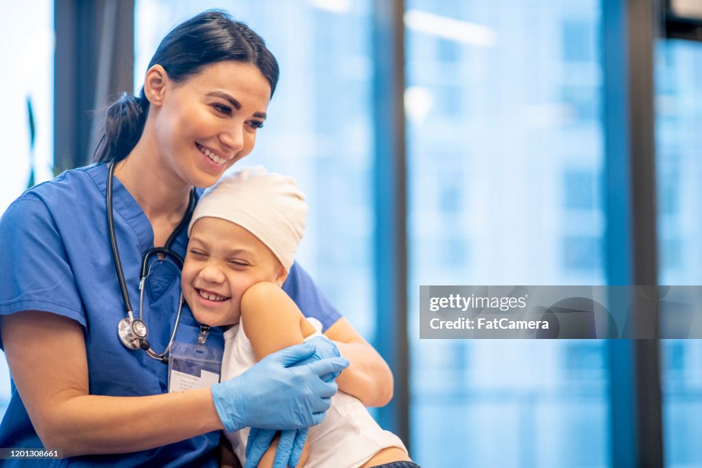 Nurse Hugging Young Cancer Patient stock photo