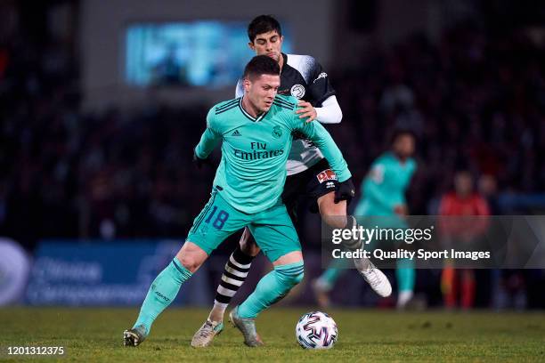 Jose Angel of Unionistas CF competes for the ball with Luka Jovic of Real Madrid CF during the Copa del Rey round of 32 match between Unionistas CF...