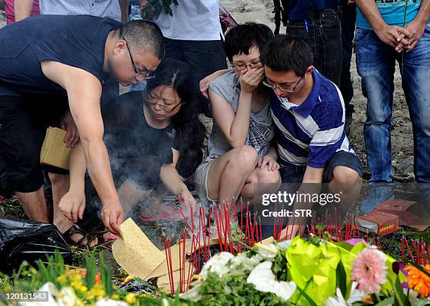 China-rail-accident,lead-FOCUS by Marianne Barriaux This photo taken on July 29, 2011 shows family members lighting and leaving sticks of incense as...