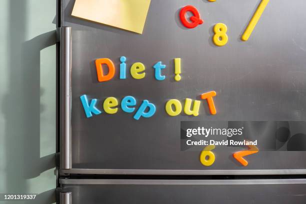 colourful magnetic letters on a silver fridge saying diet ! keep out with blank sticky notes - bokstavsmagnet bildbanksfoton och bilder