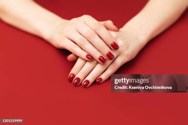 female hand with shiny red nails, manicure and nail care concept. - red nail polish stock-fotos und bilder