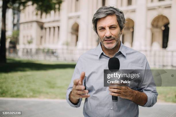 journaliste avec le microphone sur les rues de ville - présentateur de journal photos et images de collection