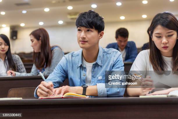 university student paying attention in class - asian american students college stock pictures, royalty-free photos & images