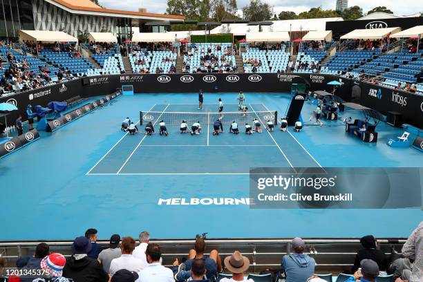 Staff are seen attempting to clean dirt off the outside courts after being caused by rainfall on day four of the 2020 Australian Open at Melbourne...