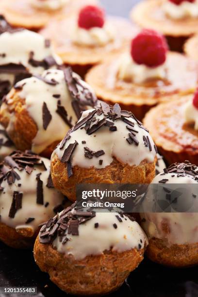 iced chocolate profiteroles - profiterole stock pictures, royalty-free photos & images