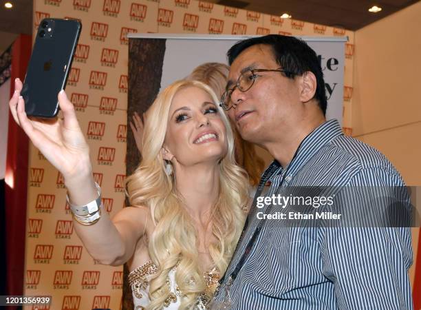 Adult film actress Charlotte Stokely takes a selfie with Ken Chow at the AVN Stars booth at the 2020 AVN Adult Entertainment Expo at the Hard Rock...