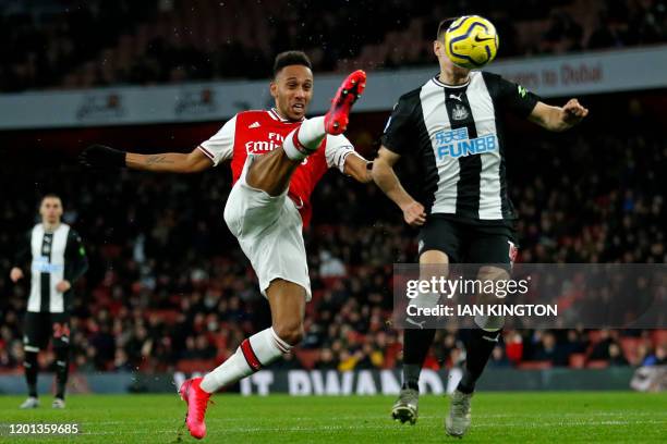 Arsenal's Gabonese striker Pierre-Emerick Aubameyang has an unsuccessful shot under pressure from Newcastle United's Argentinian defender Federico...
