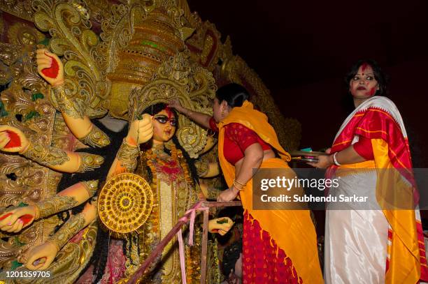 Married women pay respect and bid farewell in a ritual to goddess Durga on the last day of the festival.