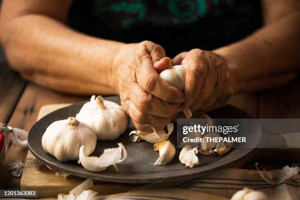 donna anziana che preleva l'aglio - aglio foto e immagini stock