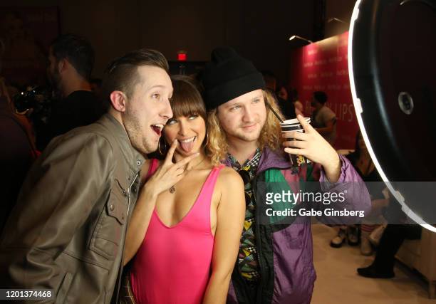 Adult film actress Riley Reid takes a selfie with Harrison Hays and Chasen Hallford of Texas in the Reid My Lips booth during the 2020 AVN Adult Expo...