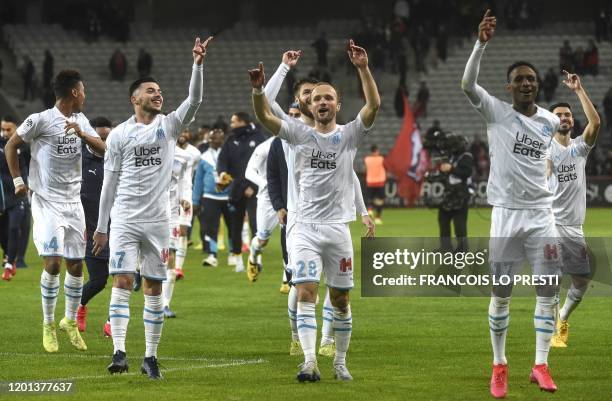 Marseille's players celebrate after winning the French L1 football match between Lille LOSC and Olympique de Marseille at the Pierre-Mauroy stadium...