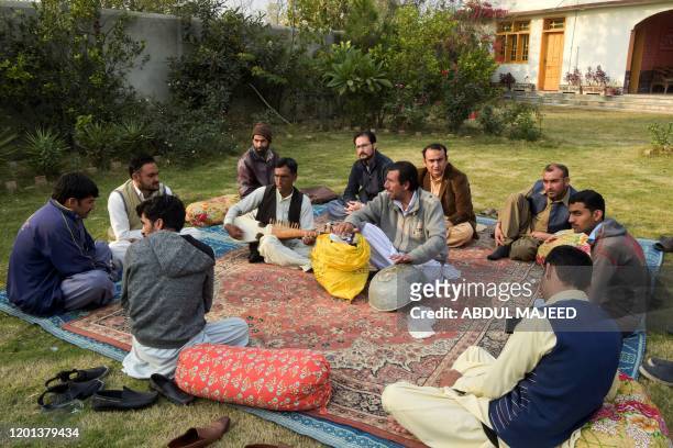 In this picture taken on December 10 Akhtar Gul plays a traditional rabab musical instrument in Peshawar. - For years the distinctive twang of...
