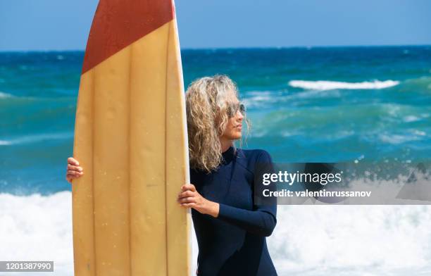 mujer surfista en busca de las olas - neoprene fotografías e imágenes de stock