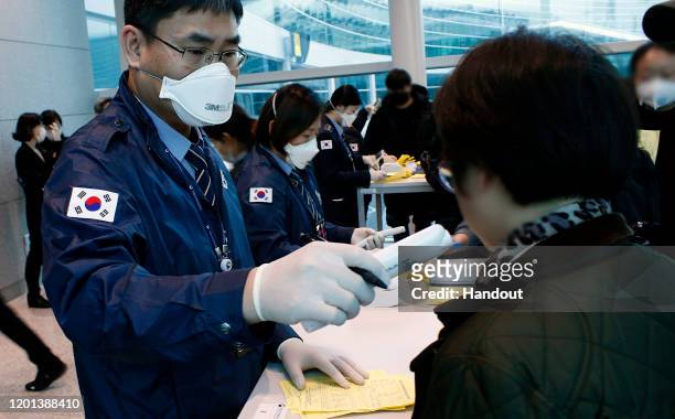 In this handout image provided by Korea Centers for Disease Control and Prevention and photo taken on January 22 South Korean quarantine officer...