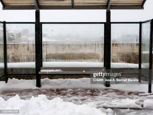 bus stop in winter with rain and snow. - bus shelter stockfoto's en -beelden